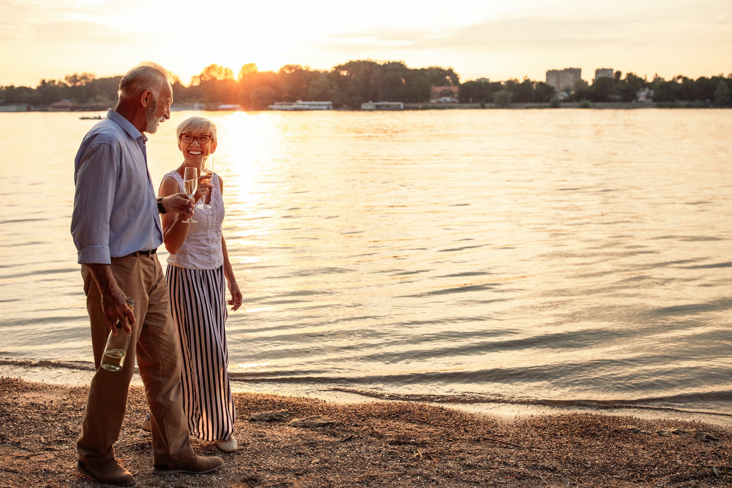 Shot of a happy senior couple drinking champagne by the river