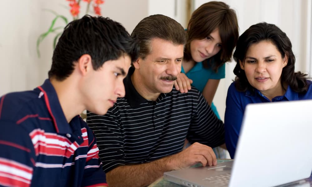 Family looking at laptop researching final expense insurance